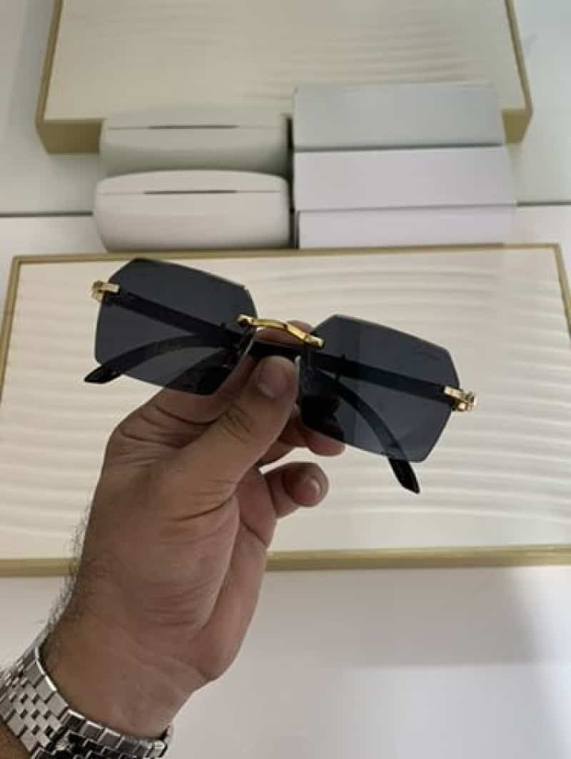 Dark smoke rimless square sunglasses - front view held in hand