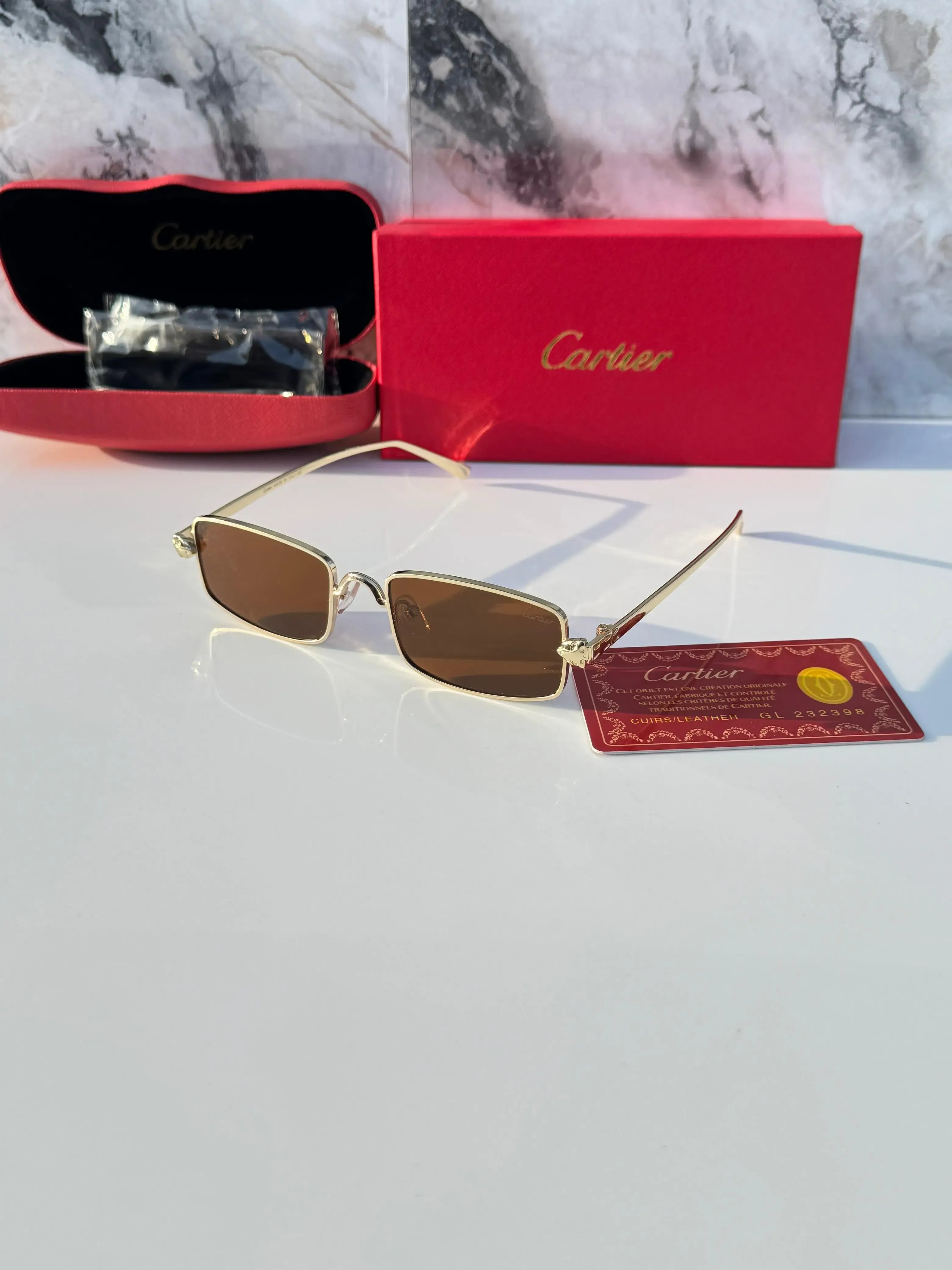 Gold rectangular sunglasses with brown lenses - flat lay with Cartier red box and authenticity card