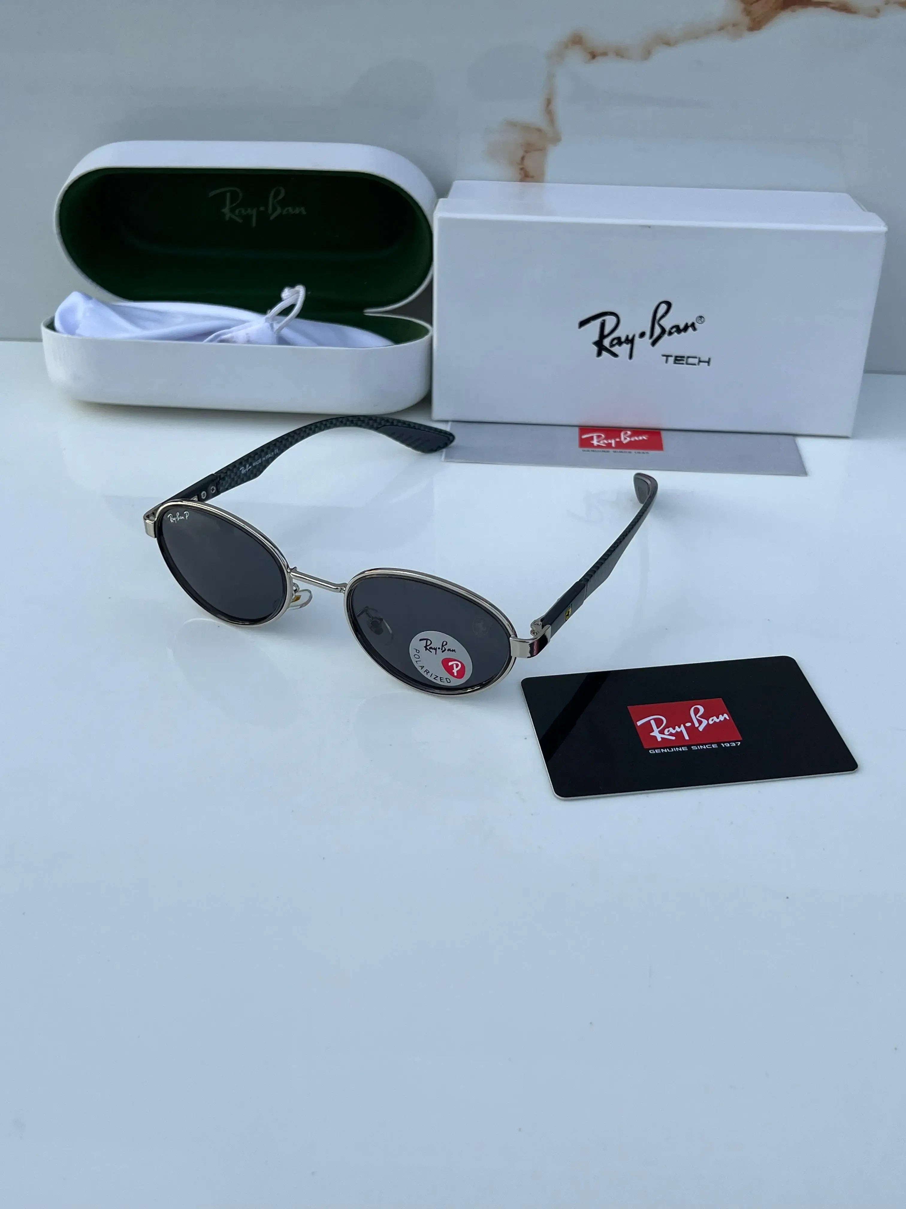 Ray-Ban x Ferrari RB8206 Silver Black - Hand holding frame showing silver oval rim with dark grey polarized lenses and Ray-Ban P logo