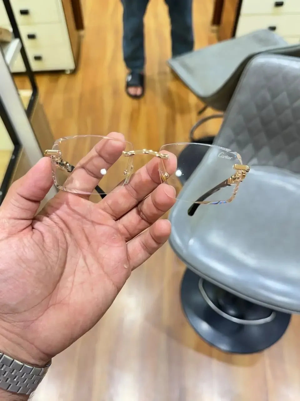 Rimless gold panther body bridge eyeglasses - close up of full panther bridge with red ruby eyes held in hand