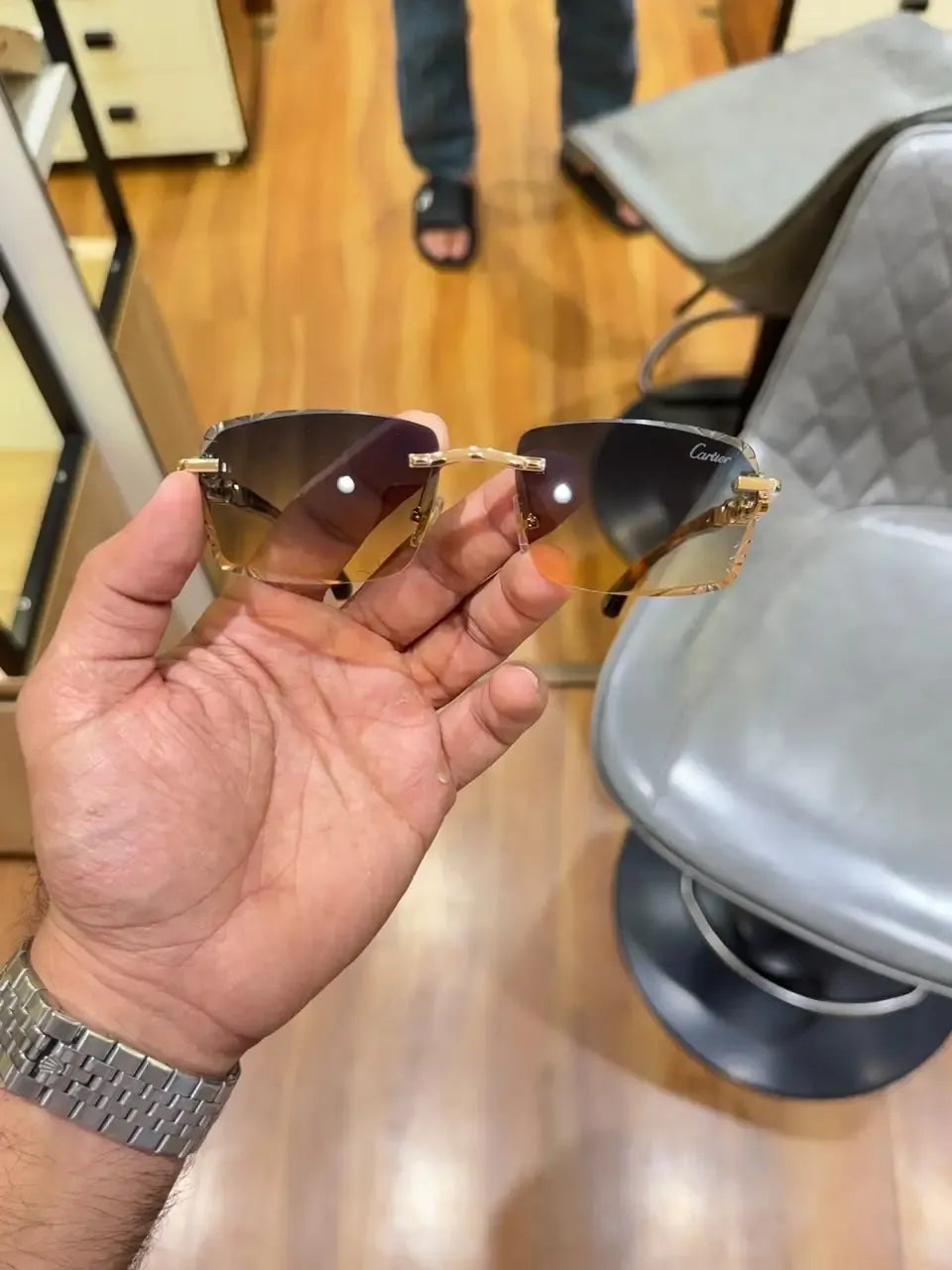 Rimless gold panther sea green sunglasses - front palm view showing sea green gradient lenses and Cartier branding