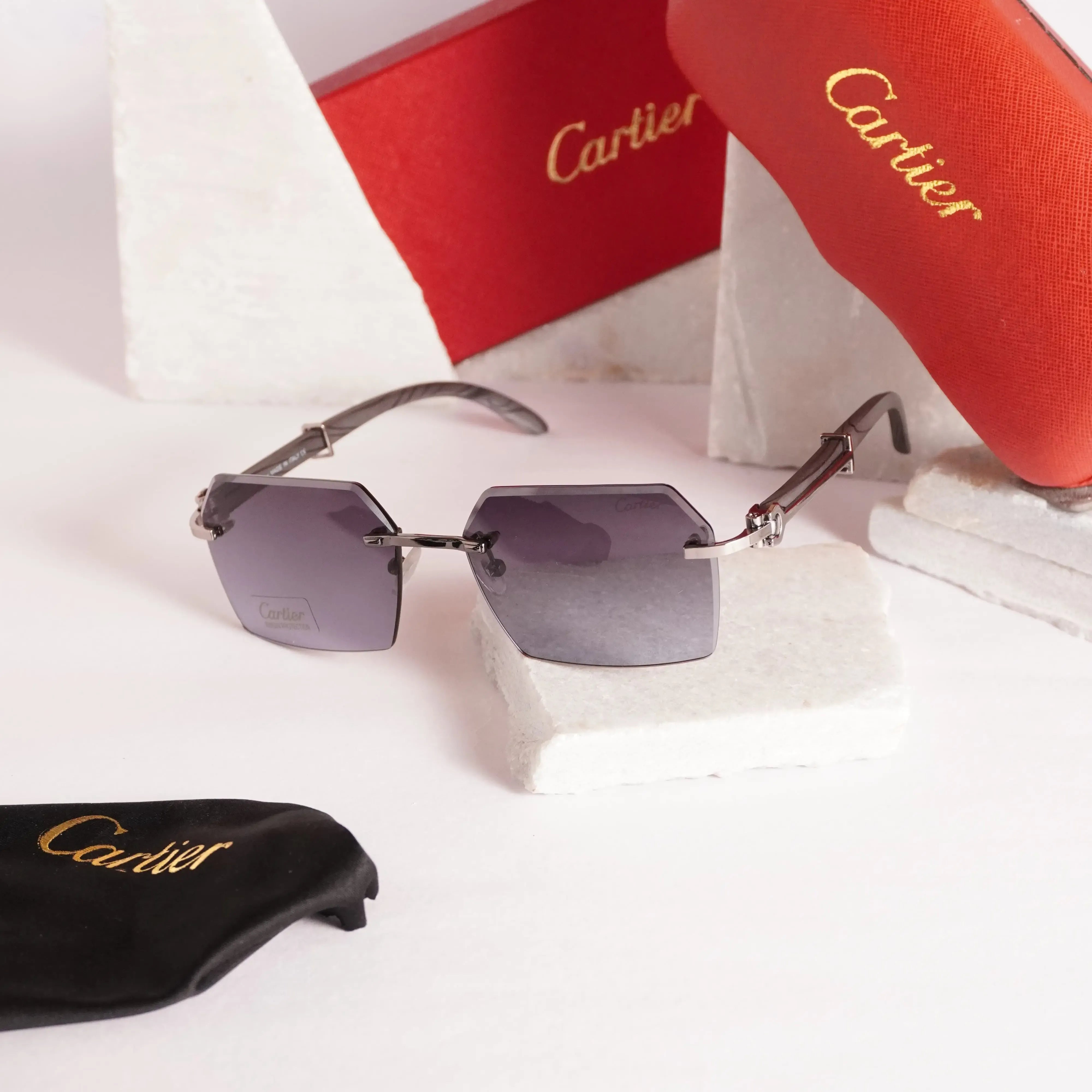 Rimless diamond-cut sunglasses - front view with grey lavender gradient lenses and Cartier box