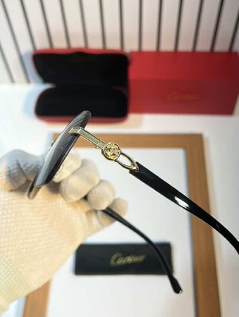 Rimless gold panther black sunglasses - front view showing dark smoke lenses and gold bridge with Cartier case