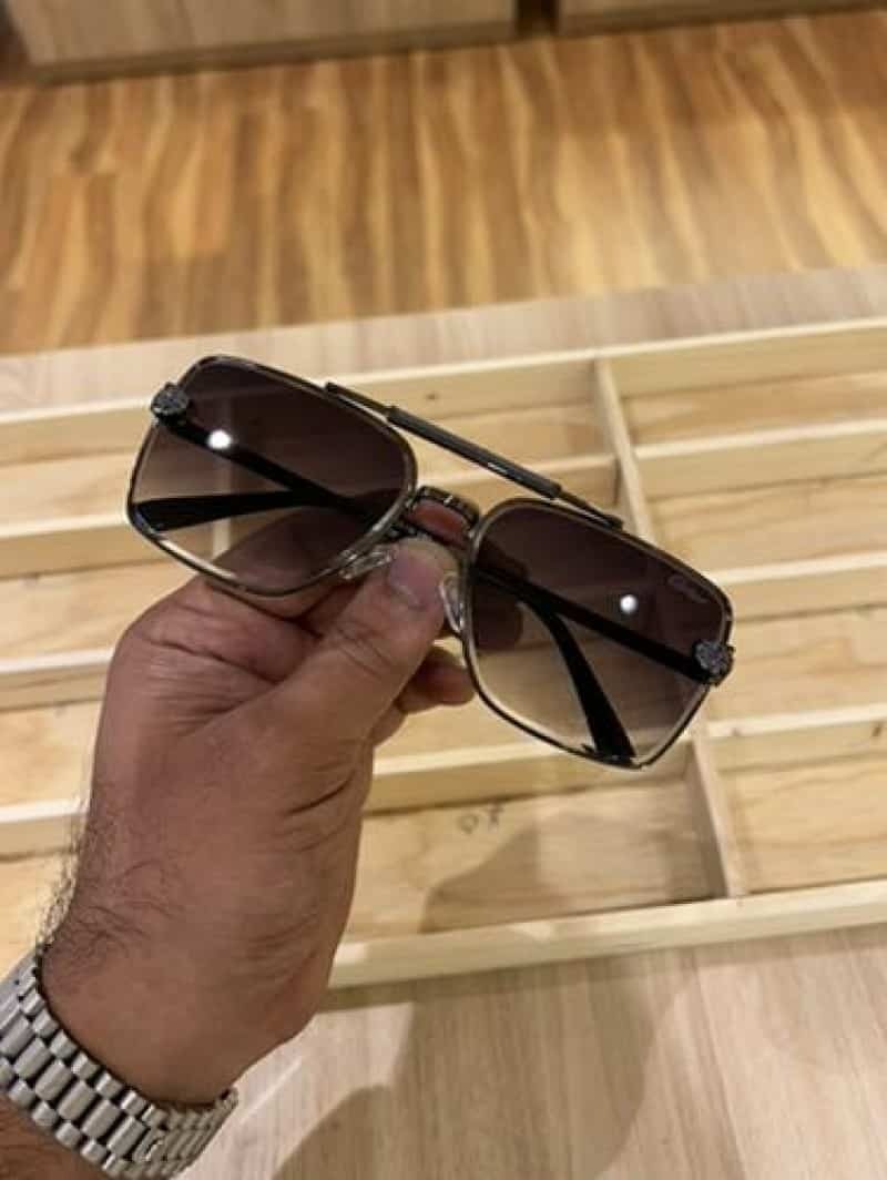 Gunmetal navigator sunglasses - held in hand showing full frame front