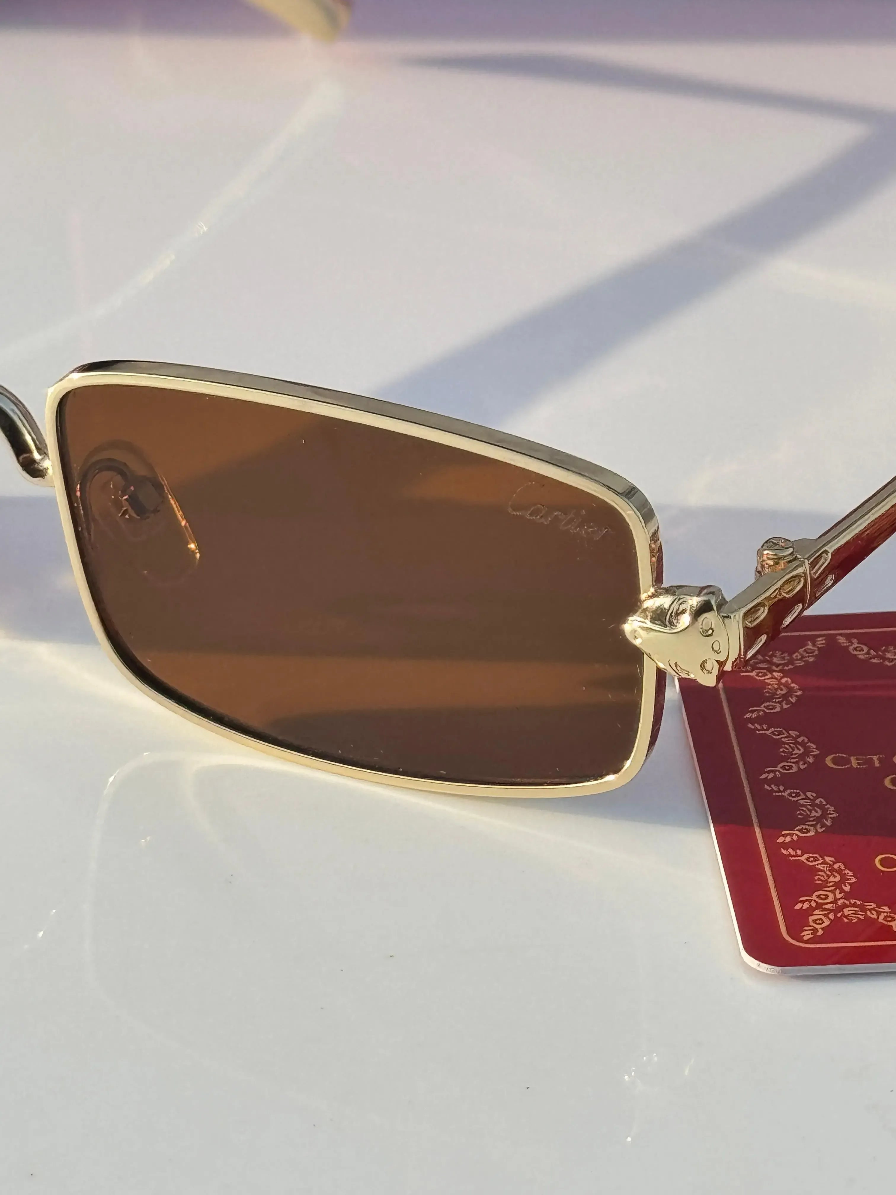 Gold rectangular sunglasses with brown lenses - 3/4 angle view with Cartier red box and card