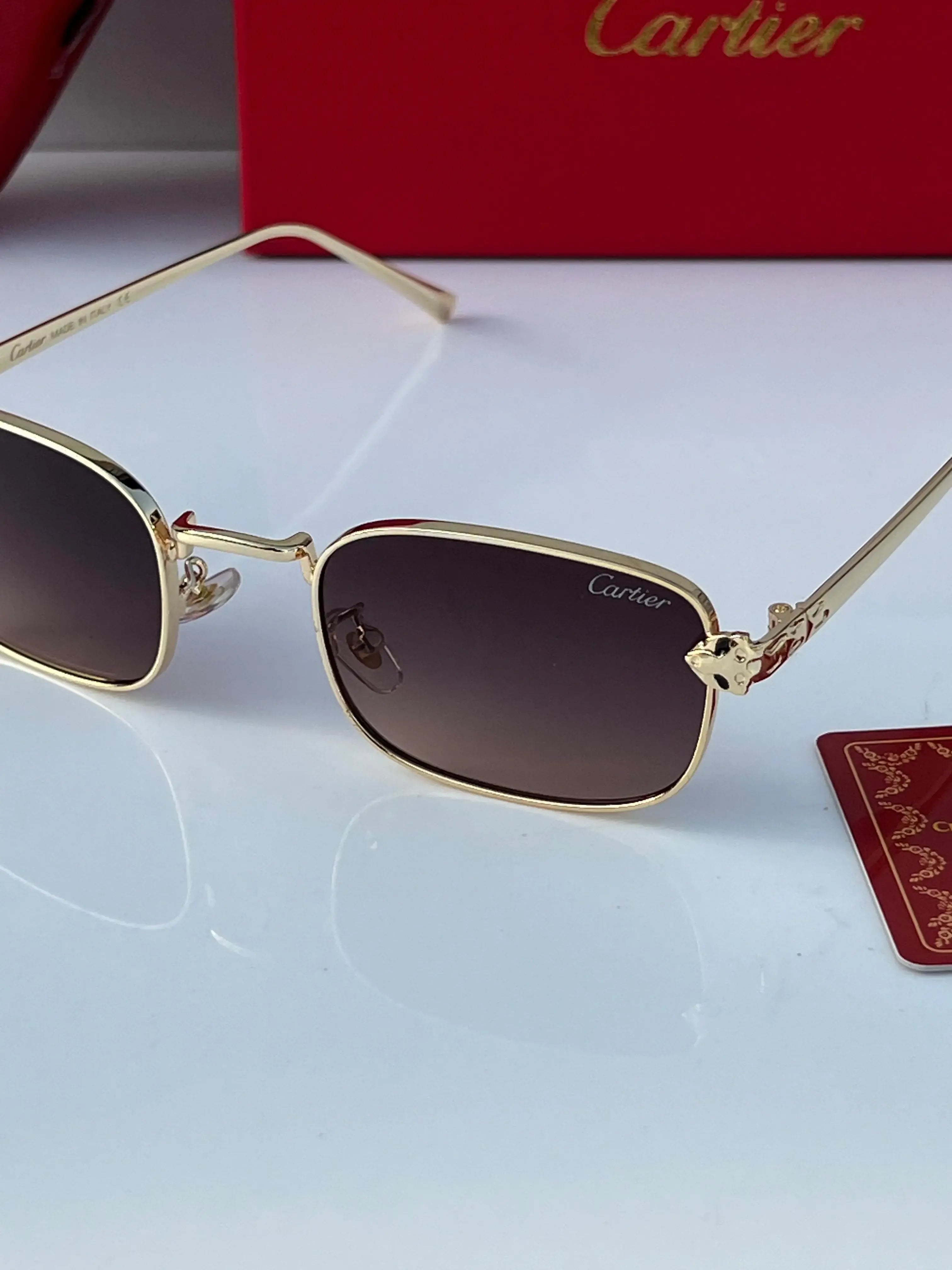 Gold rectangular sunglasses with brown gradient lenses - side 3/4 view with Cartier red case and box
