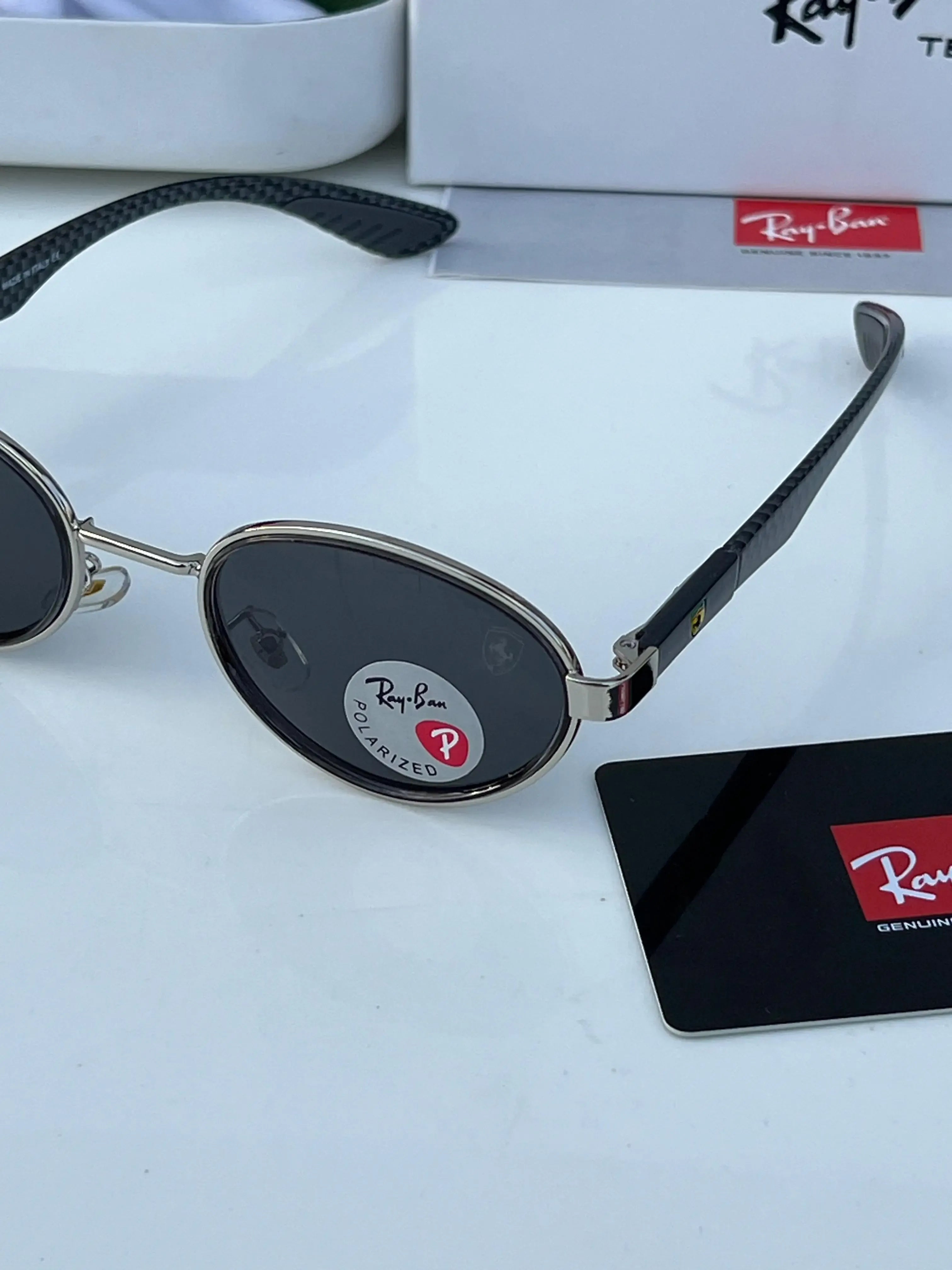 Ray-Ban x Ferrari RB8206 Silver Black - Hand holding frame showing Ray-Ban Polarized sticker on dark grey lens