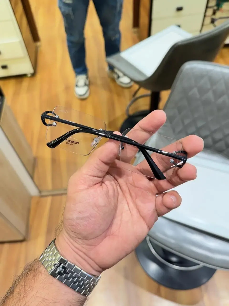 Rimless black C-frame eyeglasses - side profile showing slim black temples