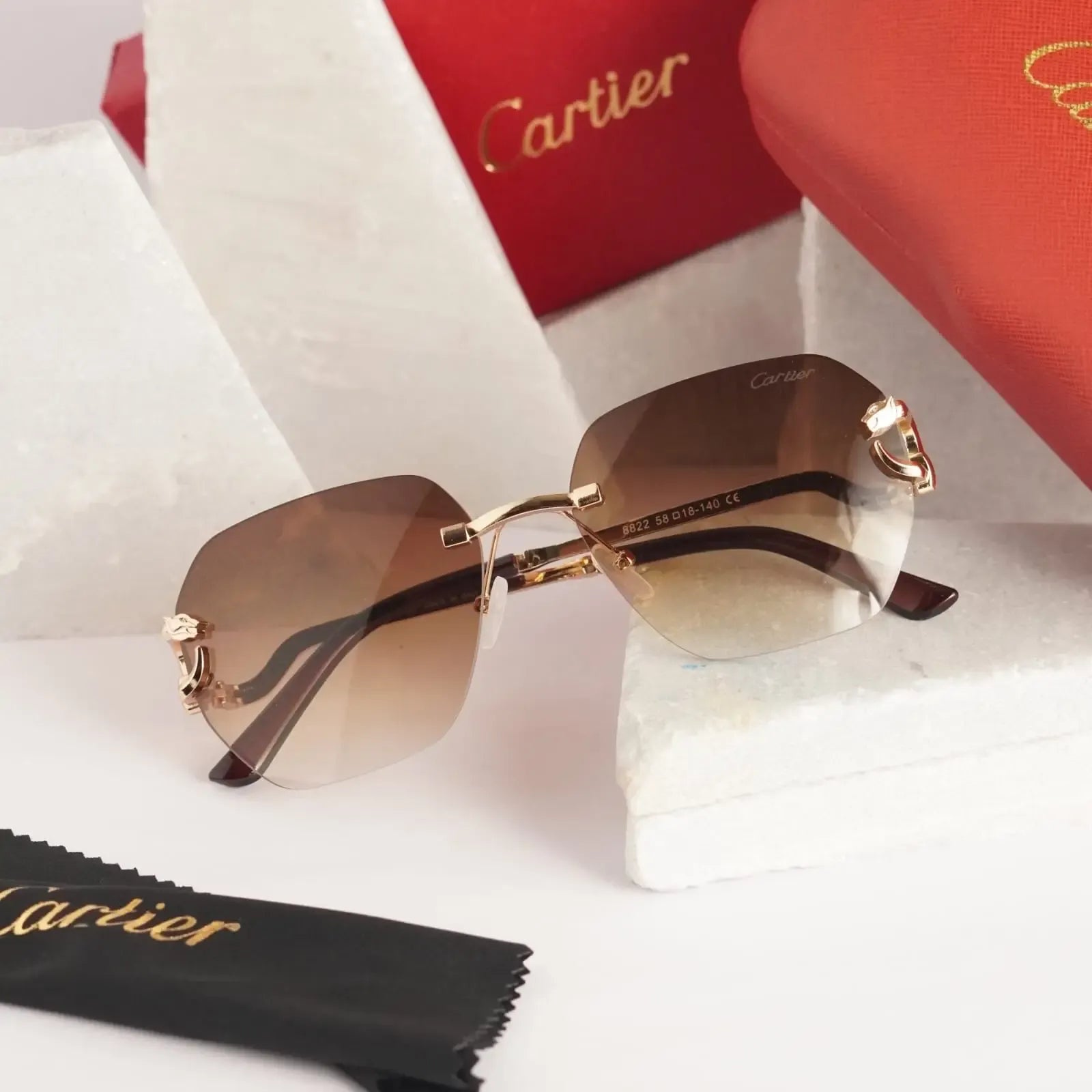 Rimless gold panther brown gradient sunglasses - front 3/4 view with Cartier red box