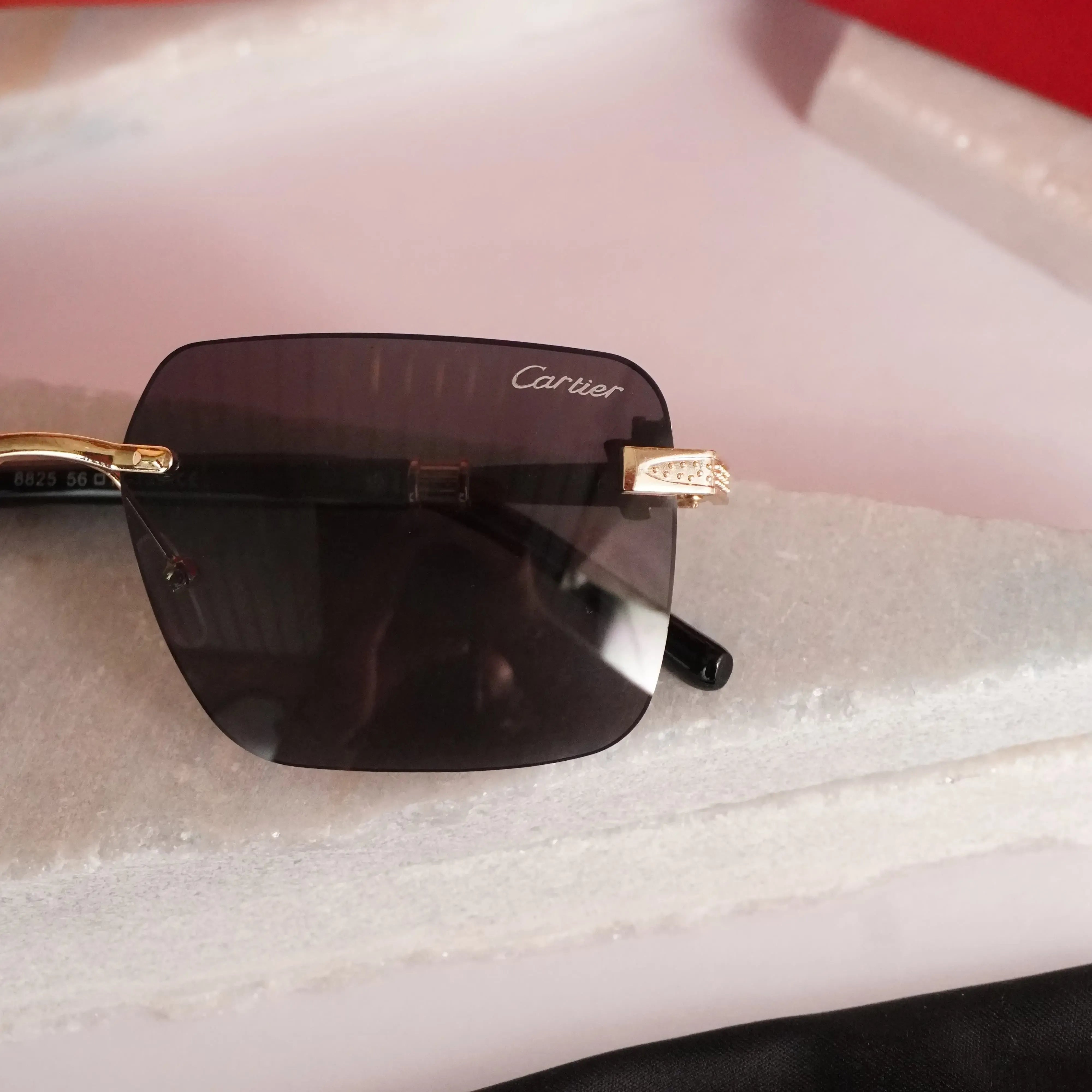 Rimless square gold black sunglasses - flat lay front view showing full frame and dark lenses