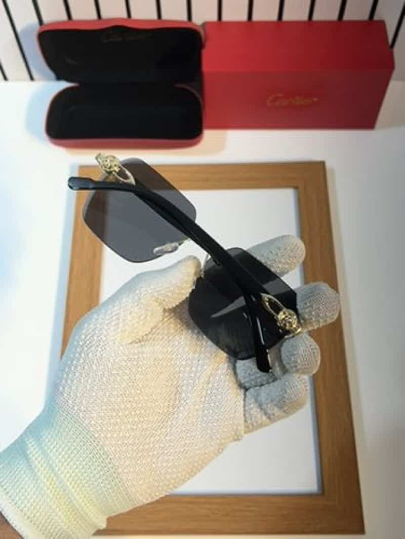 Rimless gold panther black sunglasses - close up side view of gold panther medallion hinge and black temple