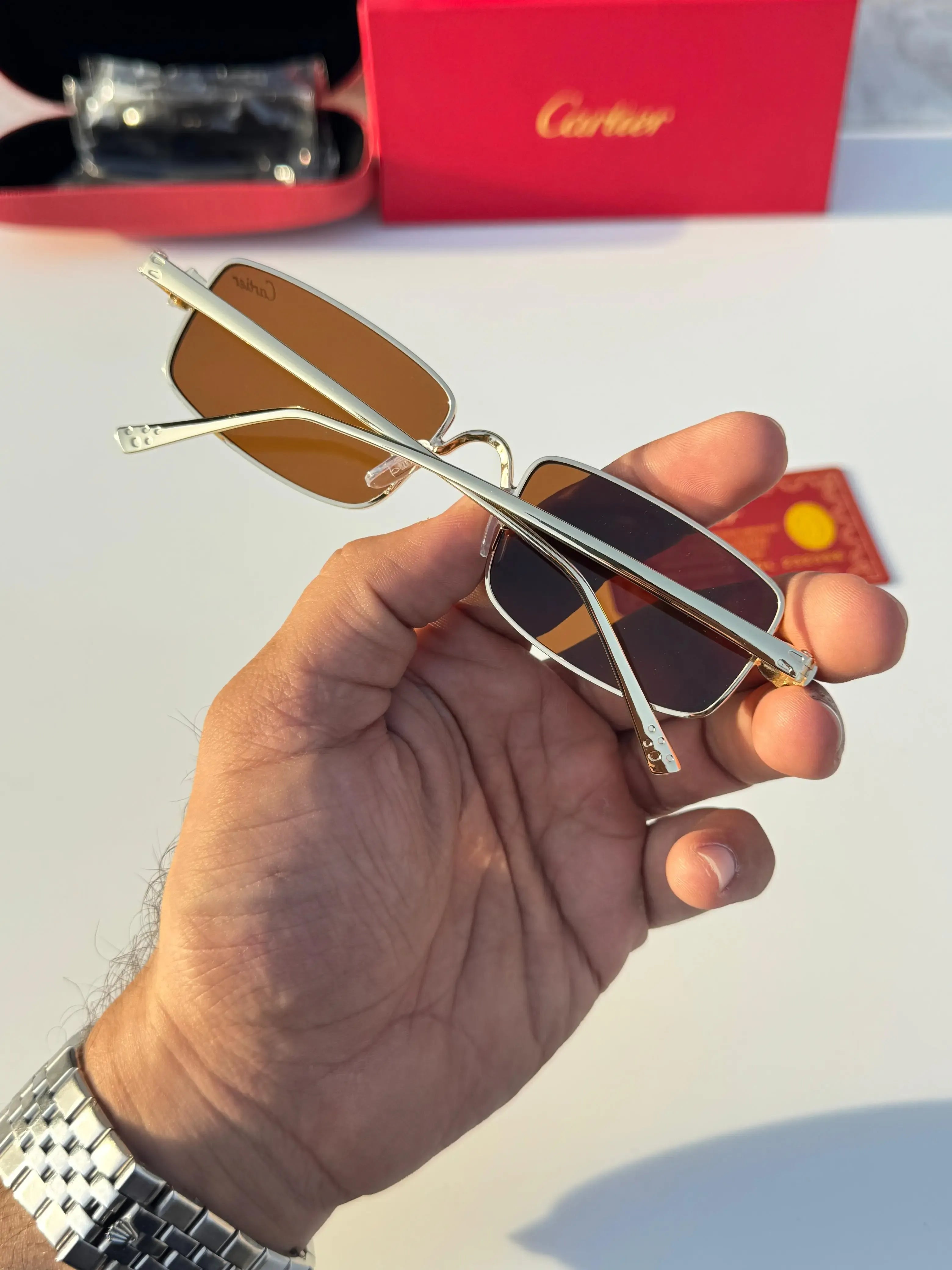Gold rectangular sunglasses with brown lenses - close up of sculpted panther hinge and brown lens detail