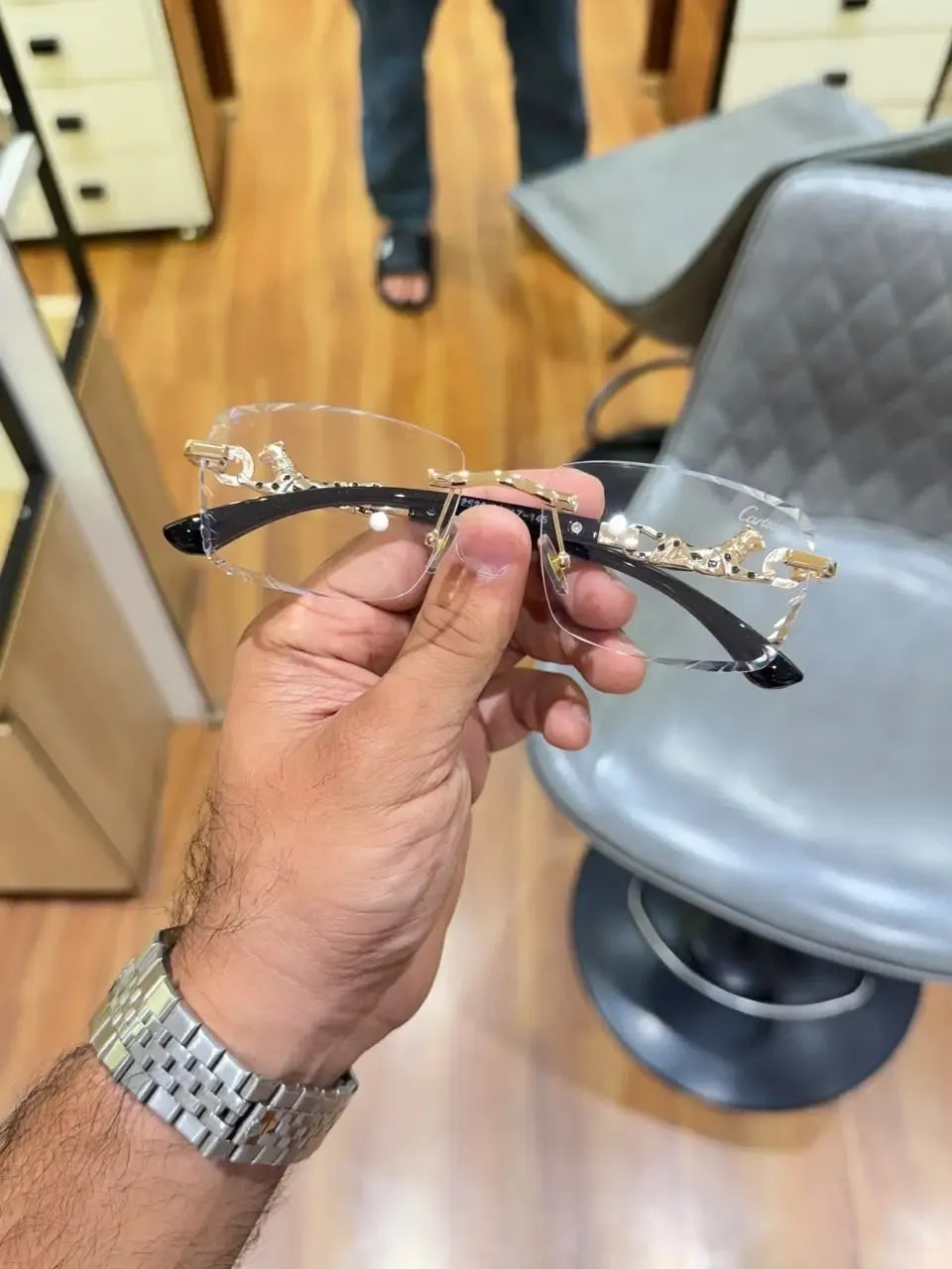 Rimless gold panther body bridge eyeglasses - side view showing black temples and panther hinge detail