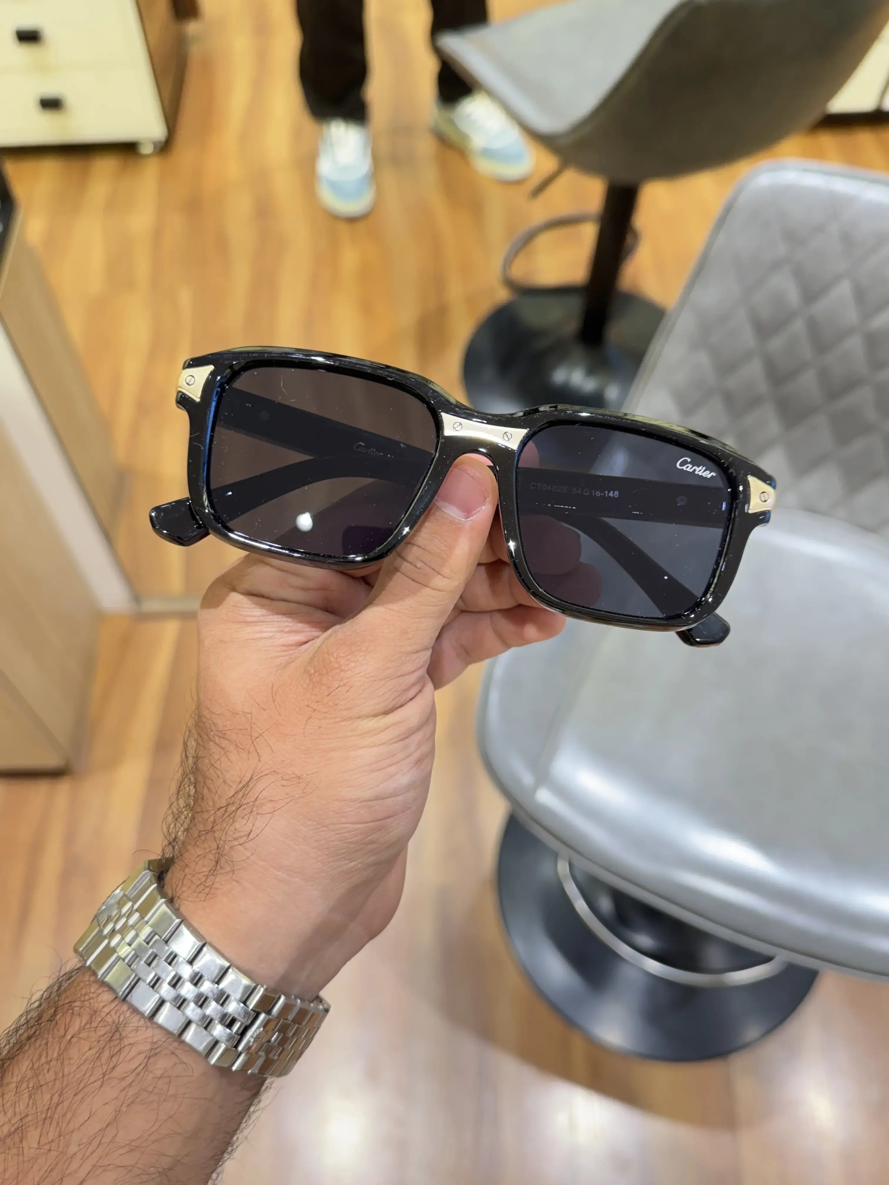 Black acetate square sunglasses with gold temple inserts - front view showing full frame and lens detail