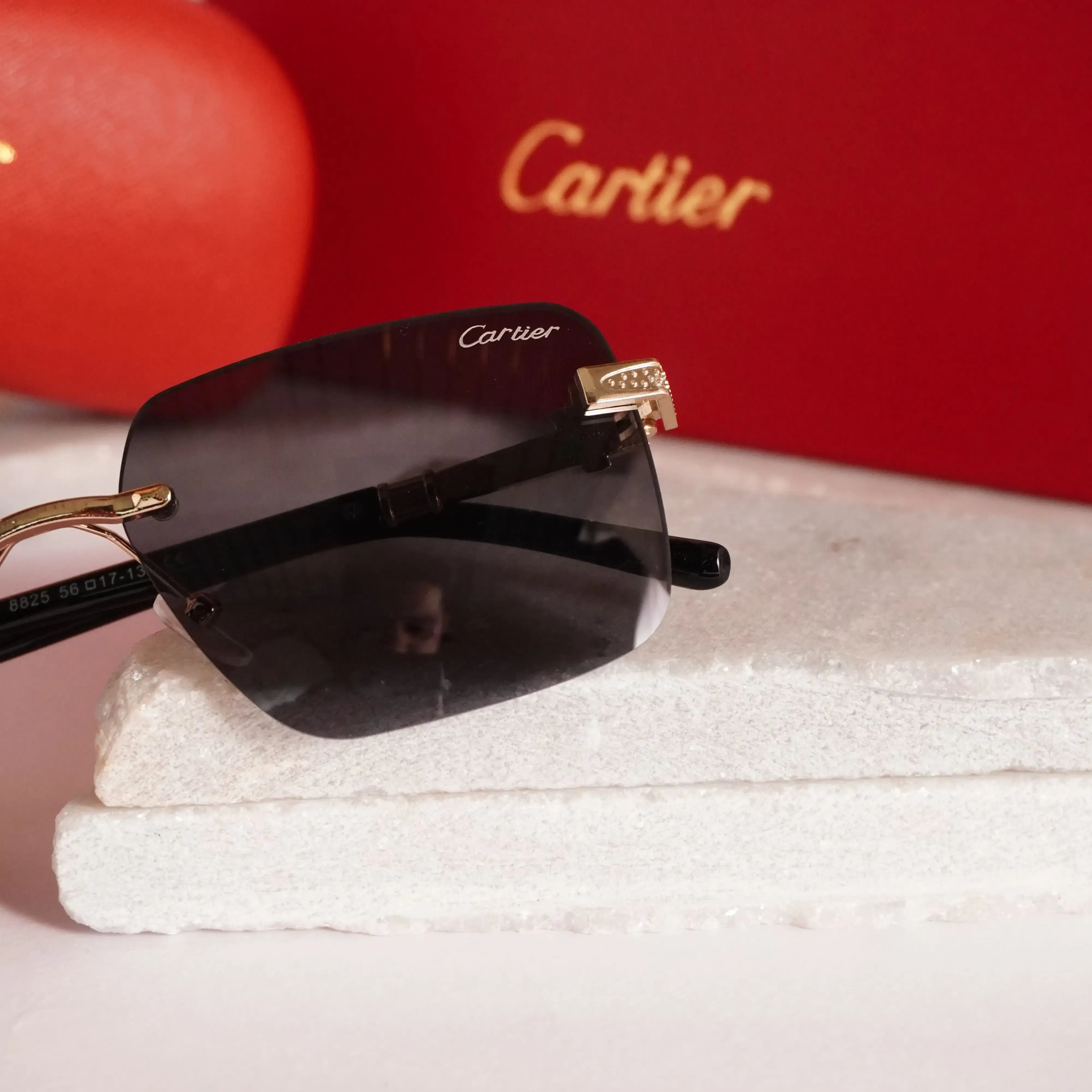 Rimless square gold black sunglasses - close up of diamond-studded gold panther hinge detail