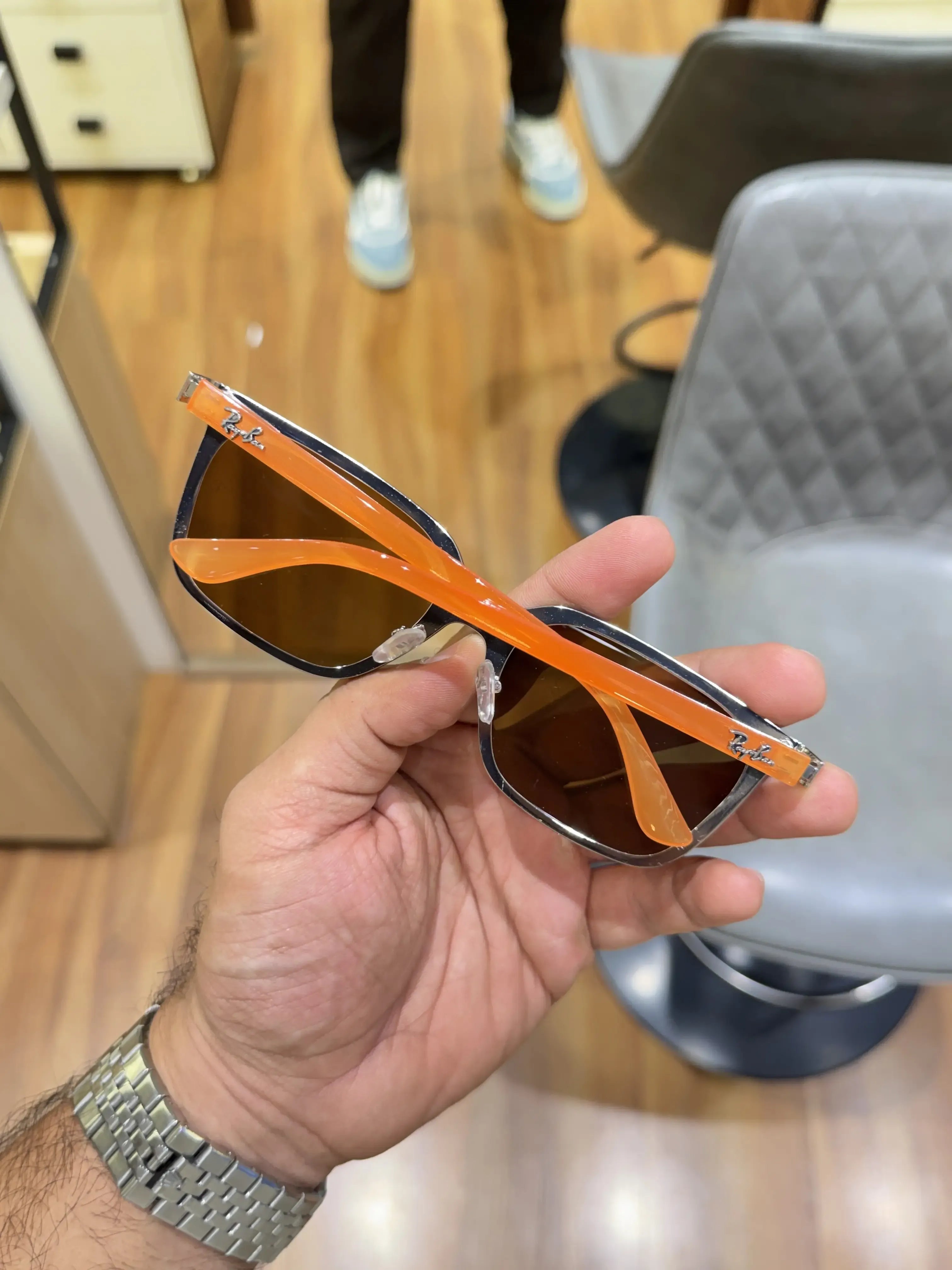 Ray-Ban RB2507S Orange Brown - Side temple view showing vibrant orange arms with Ray-Ban script logo and silver rivet hinge