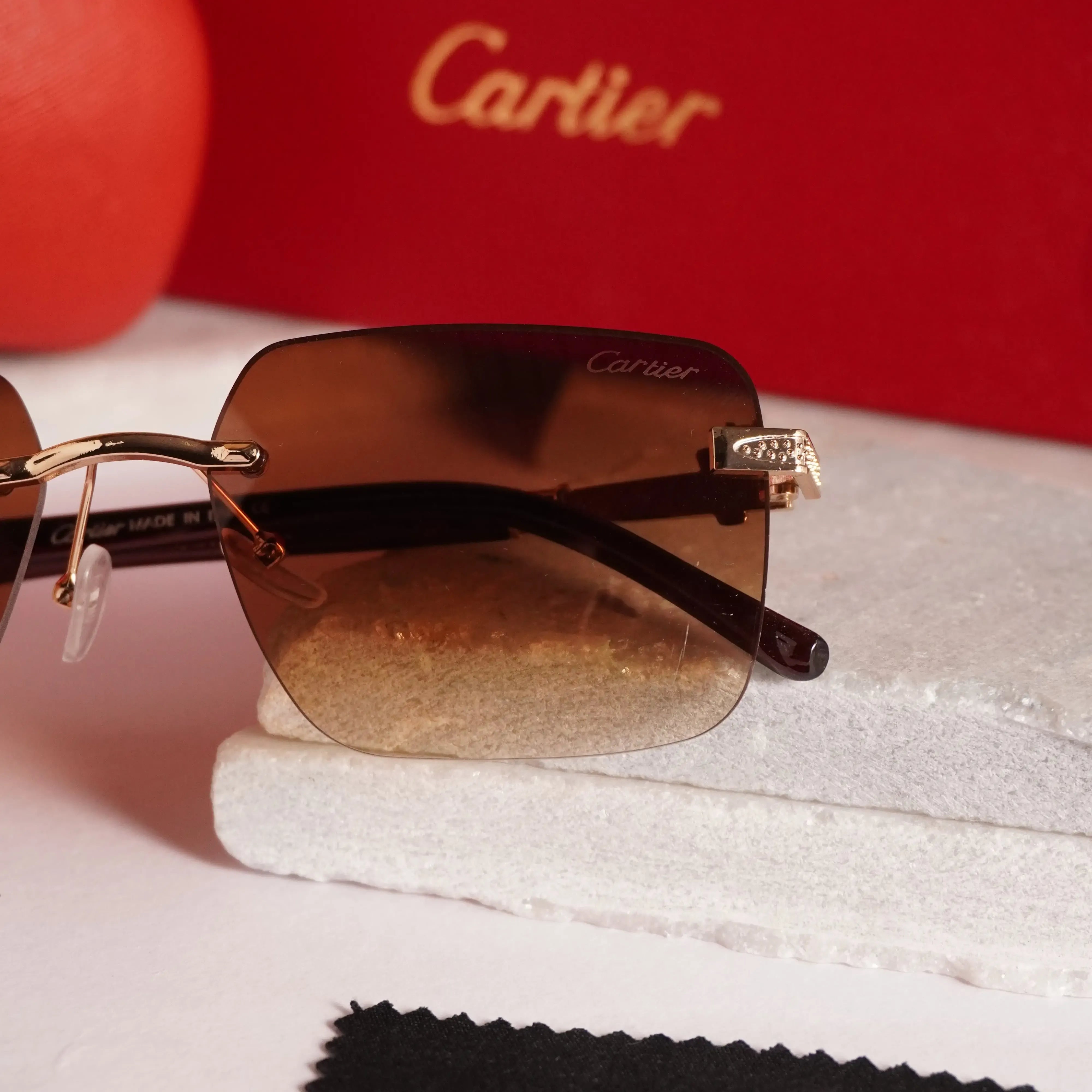 Rimless square gold brown gradient sunglasses - close up of diamond-studded gold panther hinge