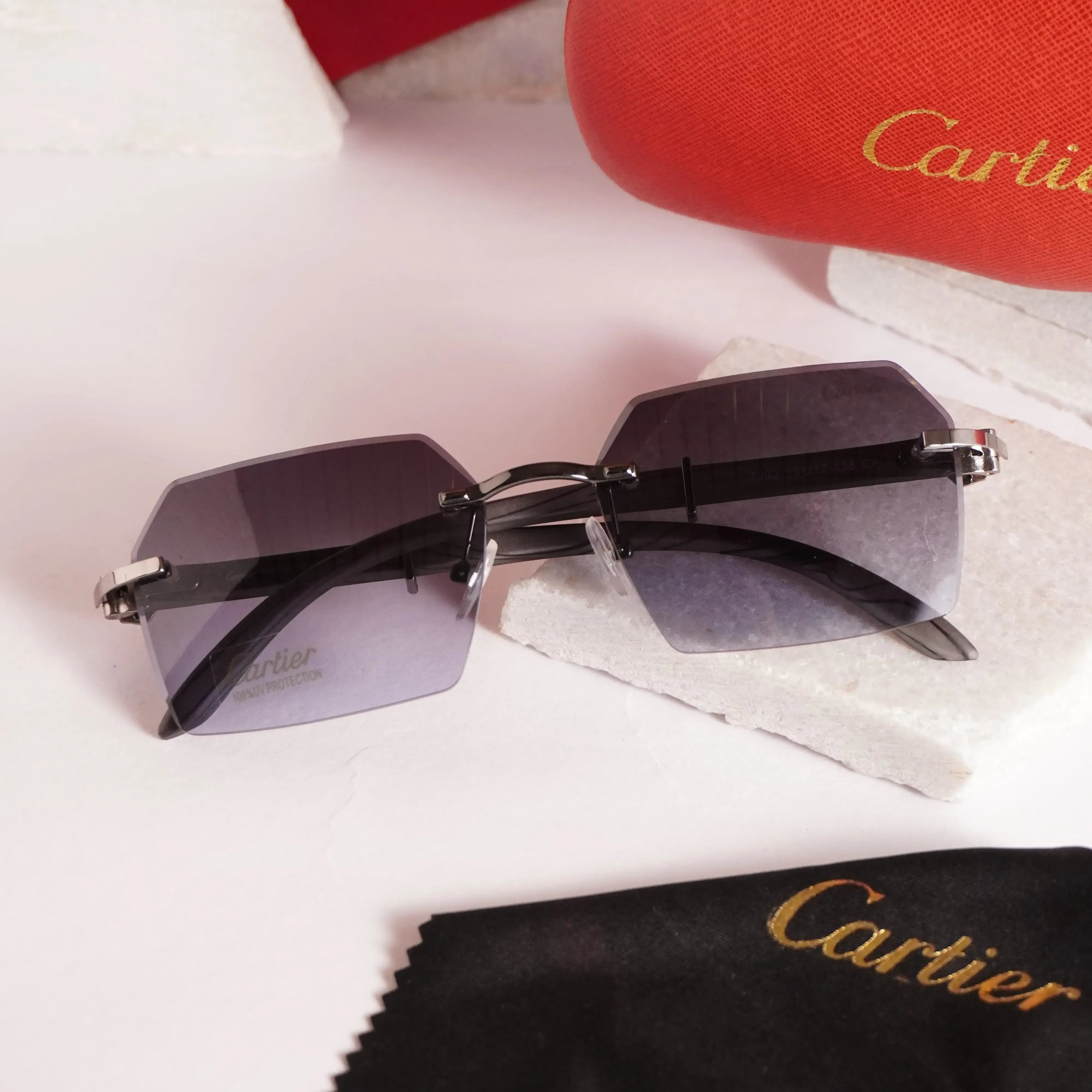 Rimless diamond-cut sunglasses - close up of gunmetal bridge and red accent hinge detail