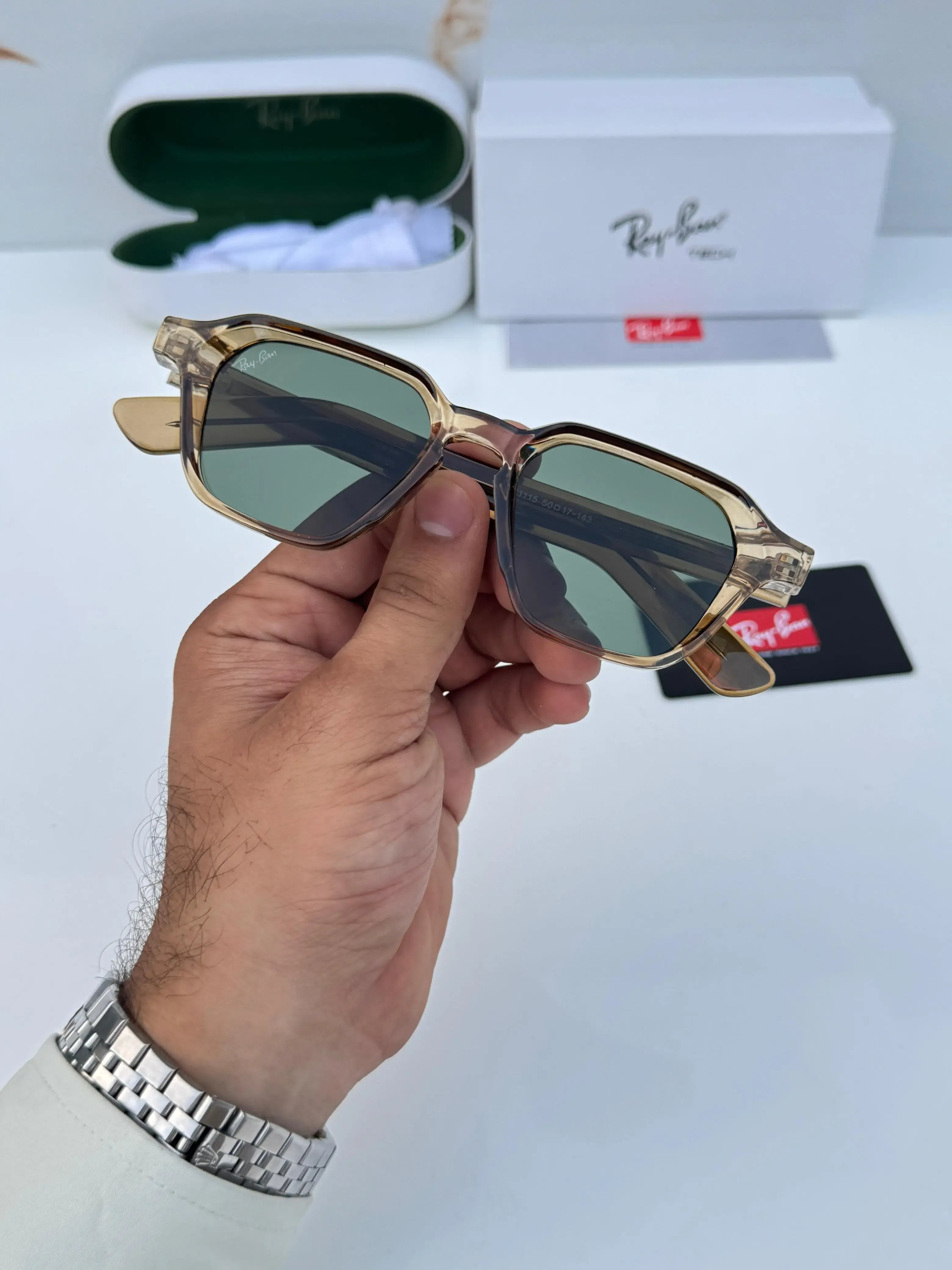Ray-Ban RB1115 Brown Green - Hand holding folded frame showing gold rivet temple detail