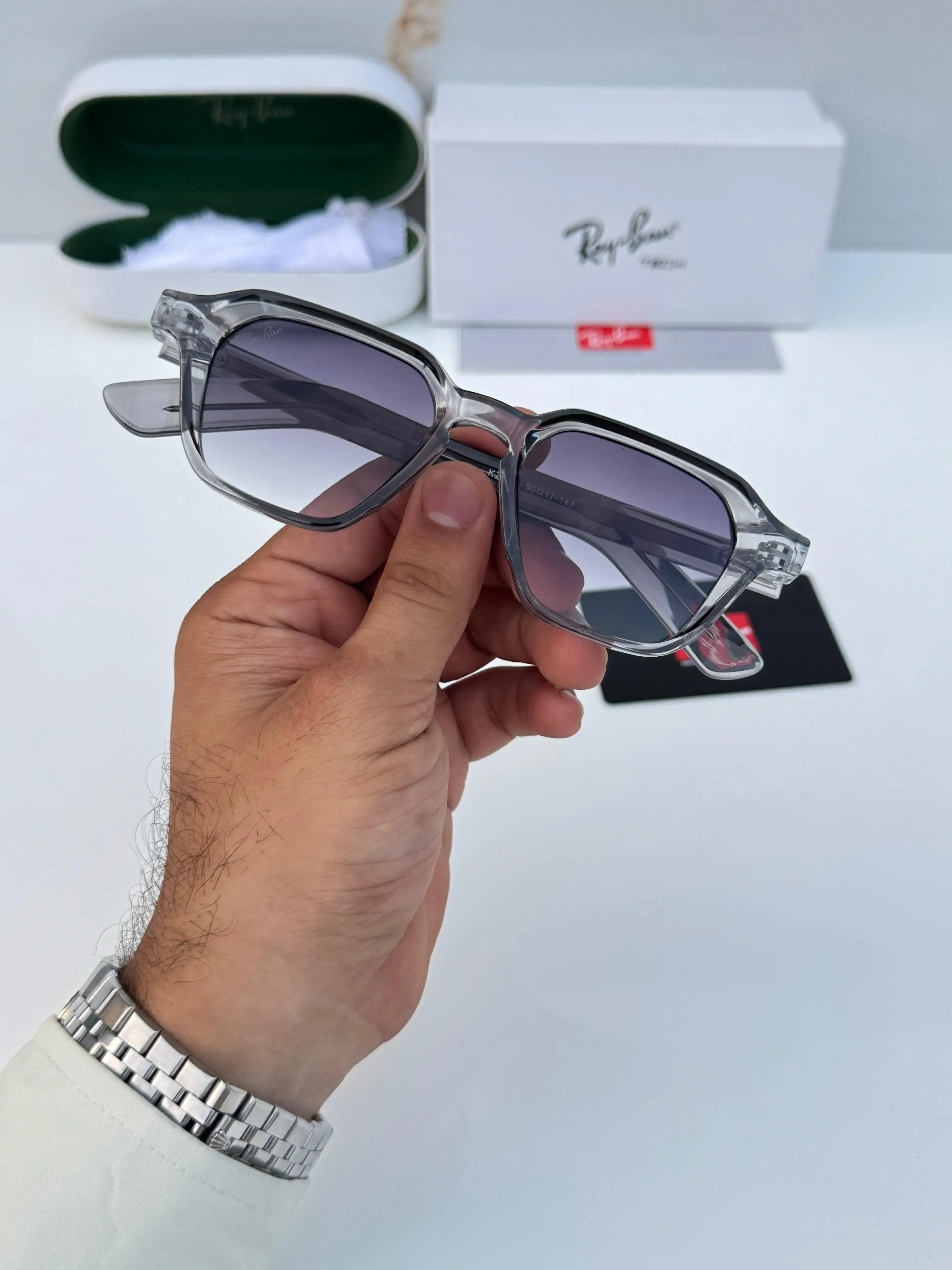 Ray-Ban RB1115 Grey Shaded - Hand holding folded frame showing silver rivet temple detail
