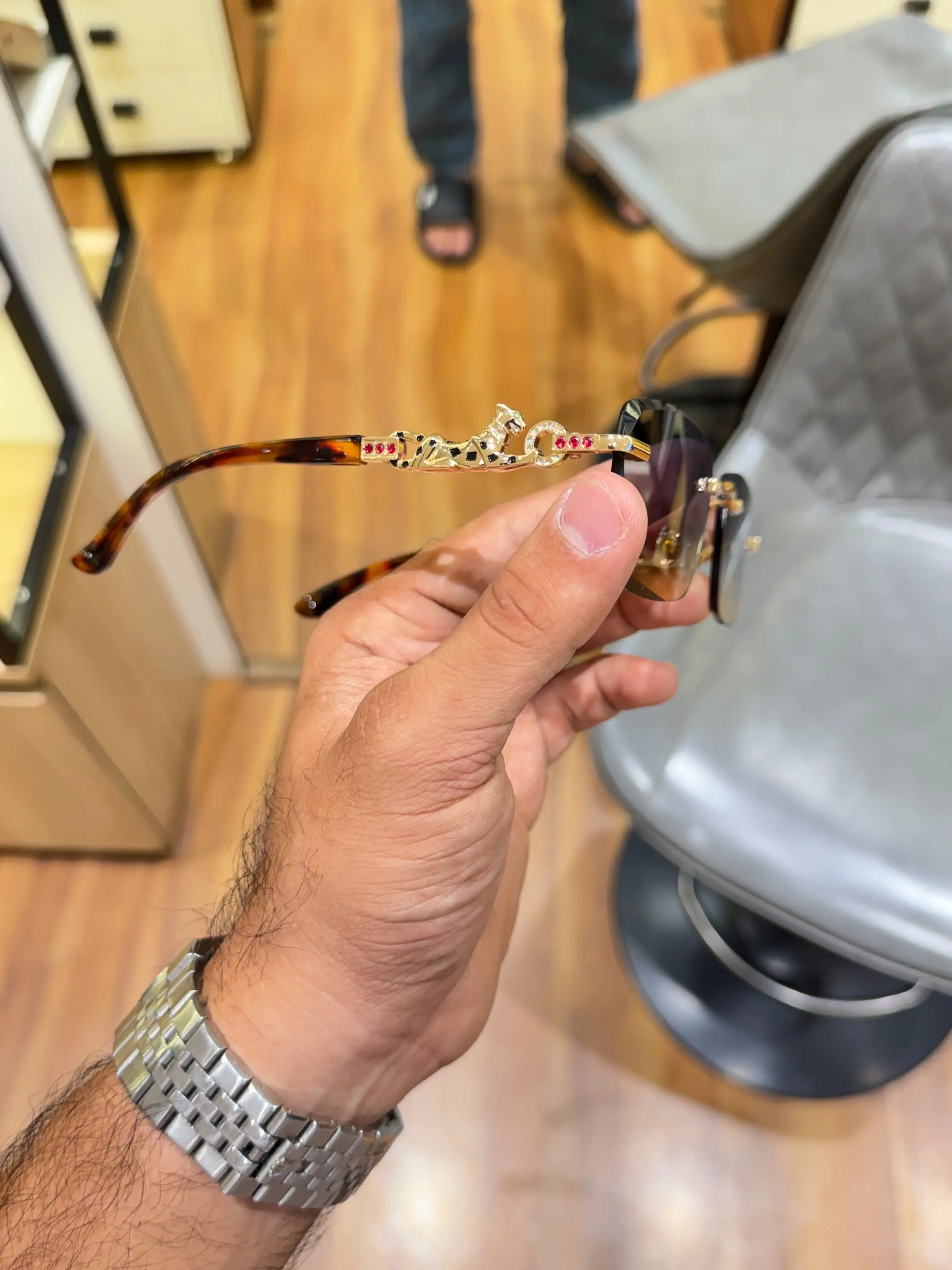 Rimless gold panther sea green sunglasses - close up side view of tortoise temple with gold panther hinge and ruby eye detail
