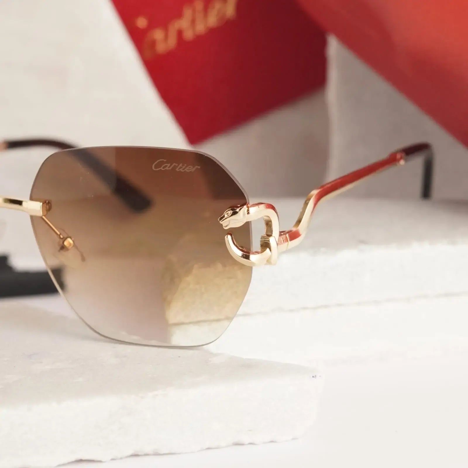 Rimless gold panther brown gradient sunglasses - close up of sculpted gold panther hinge detail