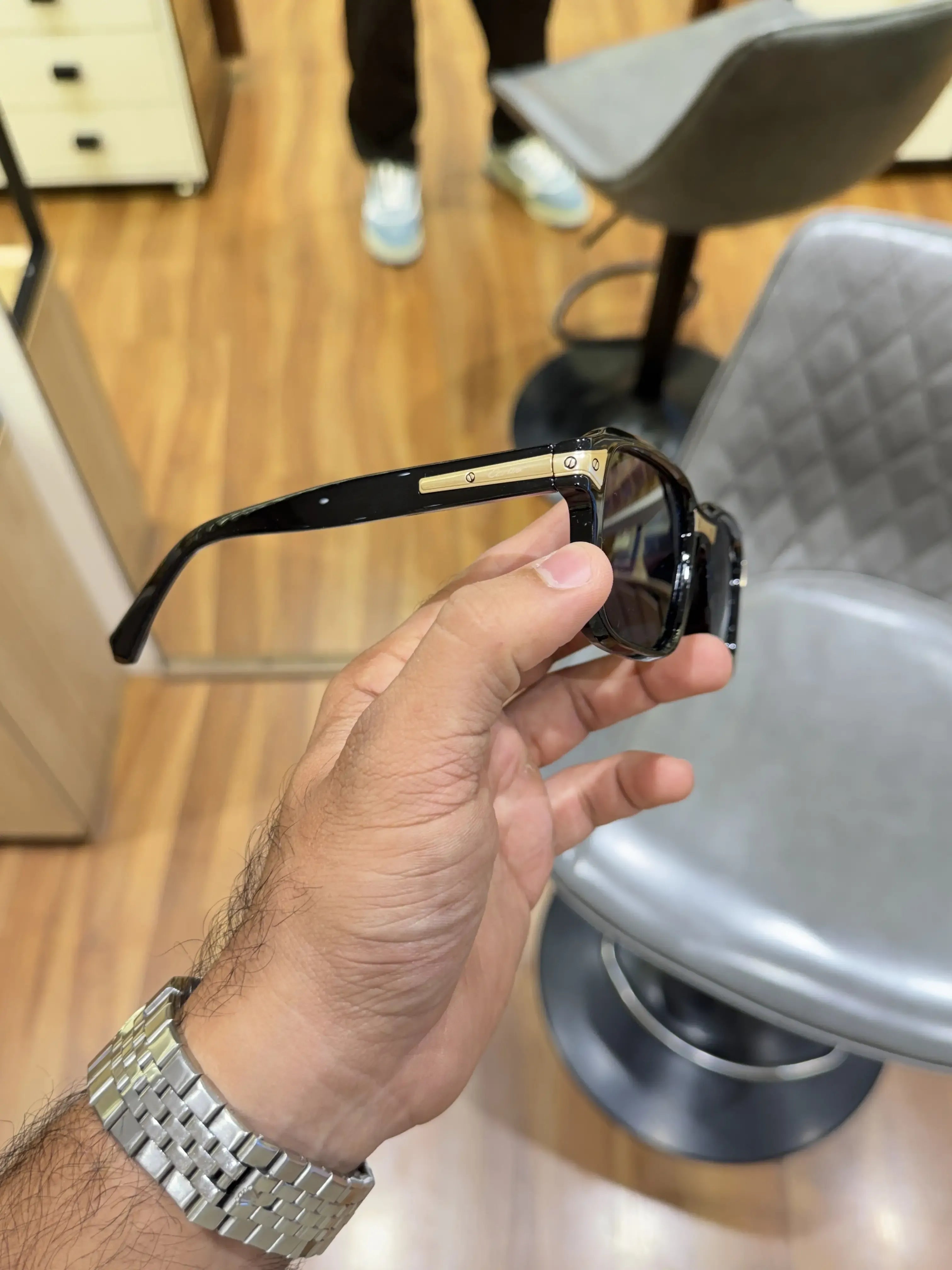 Black acetate square sunglasses with gold temple inserts - top folded view showing gold screw hinge and temple detail