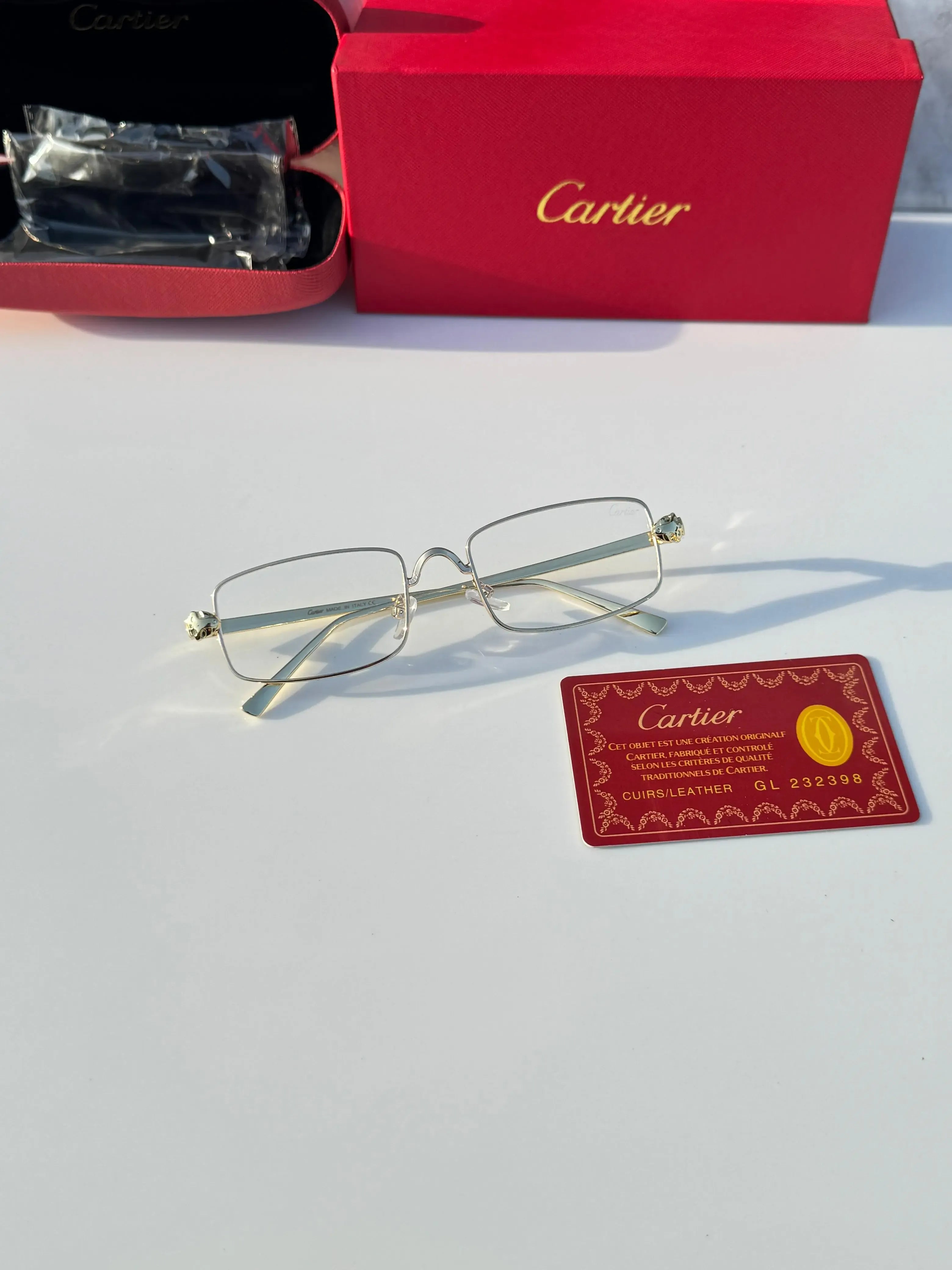 Gold rectangular eyeglasses - held in hand showing full frame